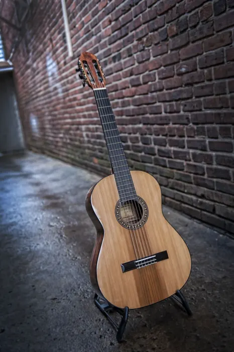 Cedar top classical guitar: standing in a brick alley